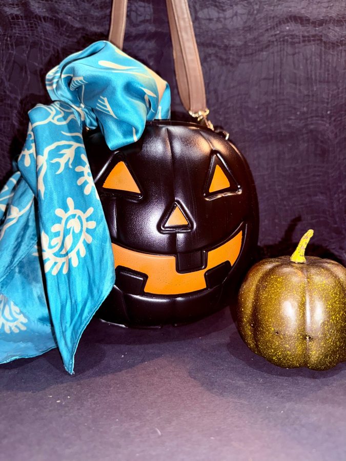 Black jack-o-lantern purse with a teal scarf and gold glitter pumpkin